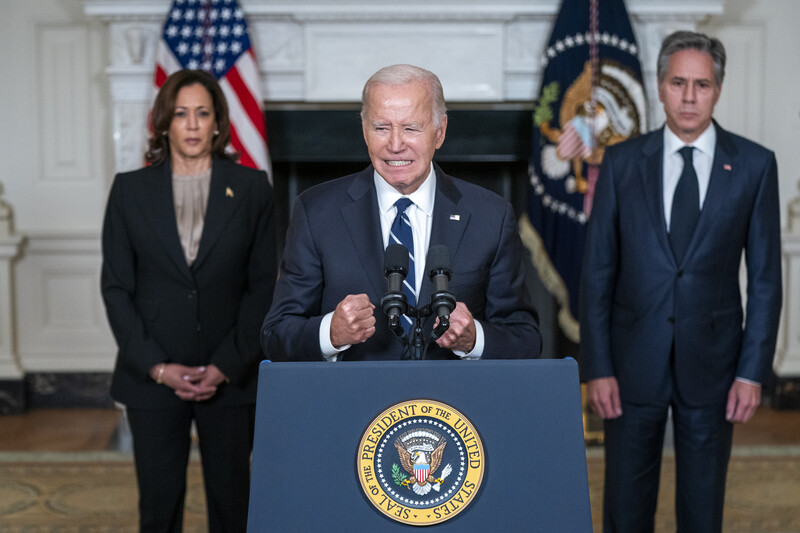 President Joe Biden speaks in the State Dining Room of the White House with Vice President Kamala Harris and Secretary of State Tony Blinken behind him 