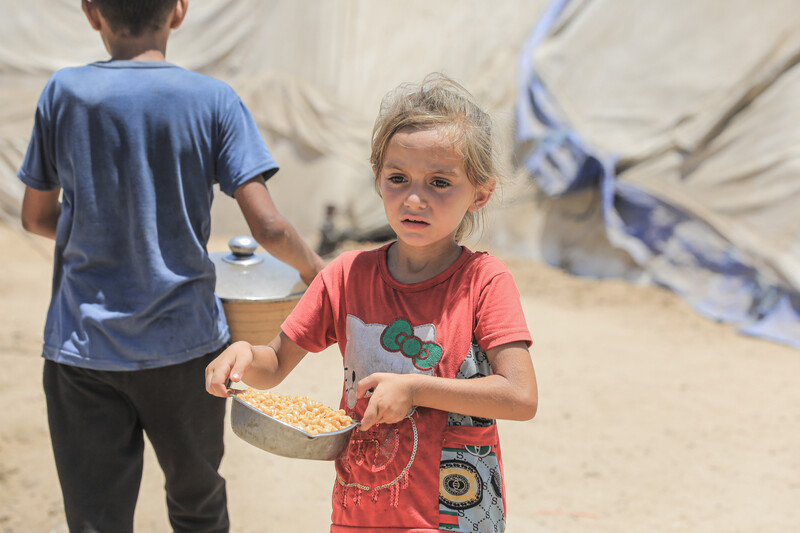 A child carries a bowl of food