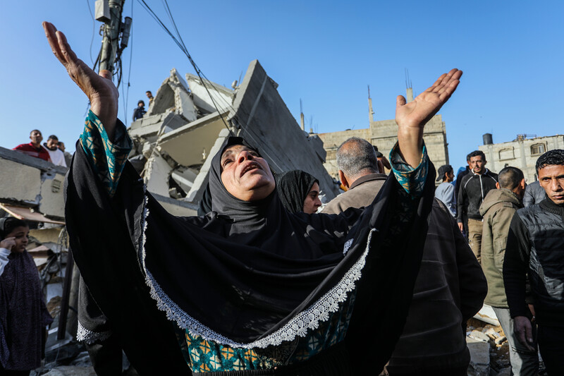 A woman raises her hands to the sky