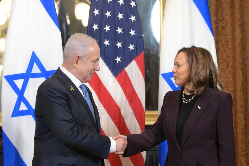 US Vice President Kamala Harris shakes hands with Israeli Prime Minister Benjamin Netanyahu with an American flag and two Israeli flags behind them