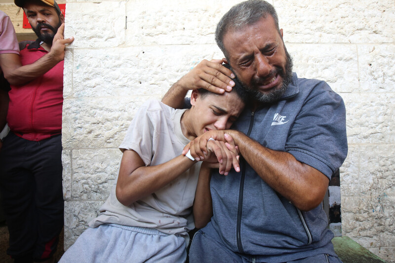 Man and boy cry as they embrace one another 