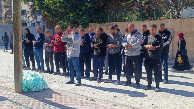 A group of people pray on a pavement