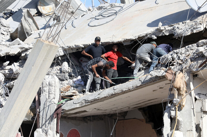 Men stand in the rubble of a building