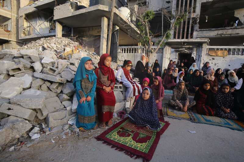 Girls pray in rubble for the Eid al-ADha