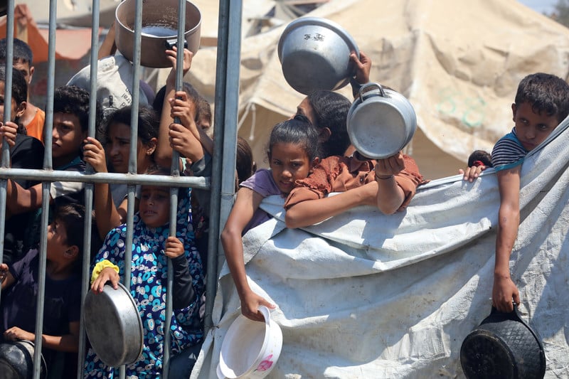 Children with empty pots await food aid