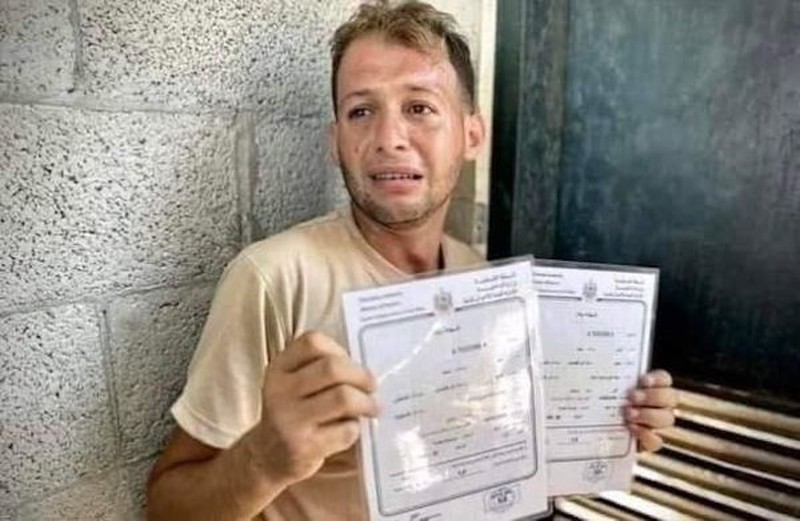 A tearful man holds up two birth certificates