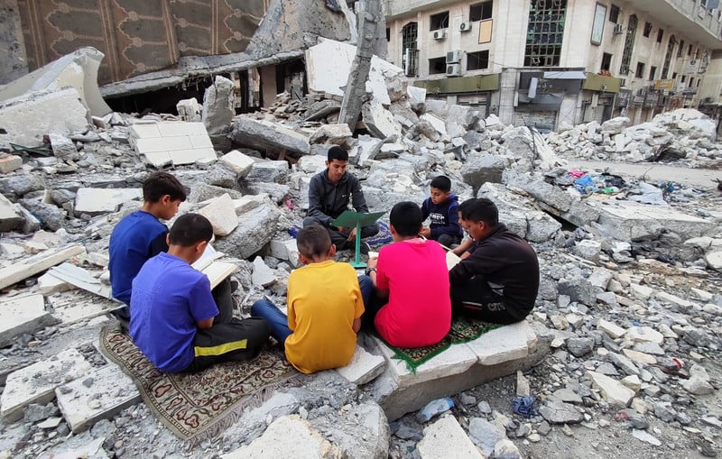 children read amid rubble