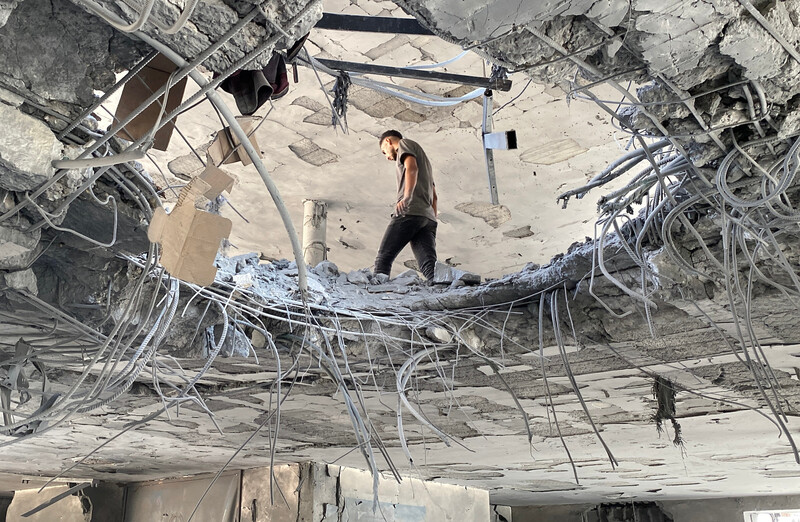 Photo taken from below shows man walking next to hole in floor of multi-story building