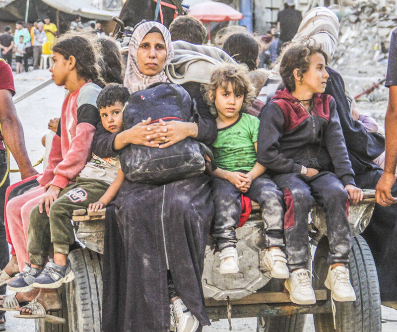 A Palestinian woman and children on a cart depart Jabaliya