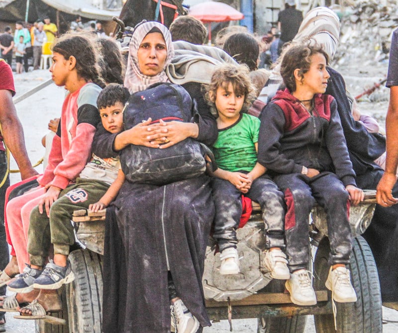 A Palestinian woman and children on a cart depart Jabaliya