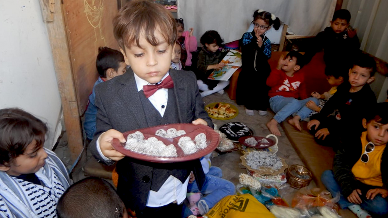 A boy holds a plate of treats