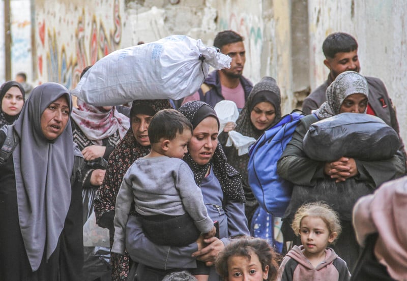 People carrying belongings, children and bags of rice are displaced from Jabaliya