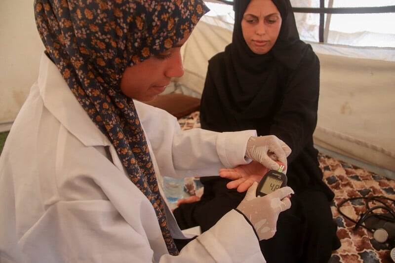 A nurse takes blood pressure from a pregnant woman