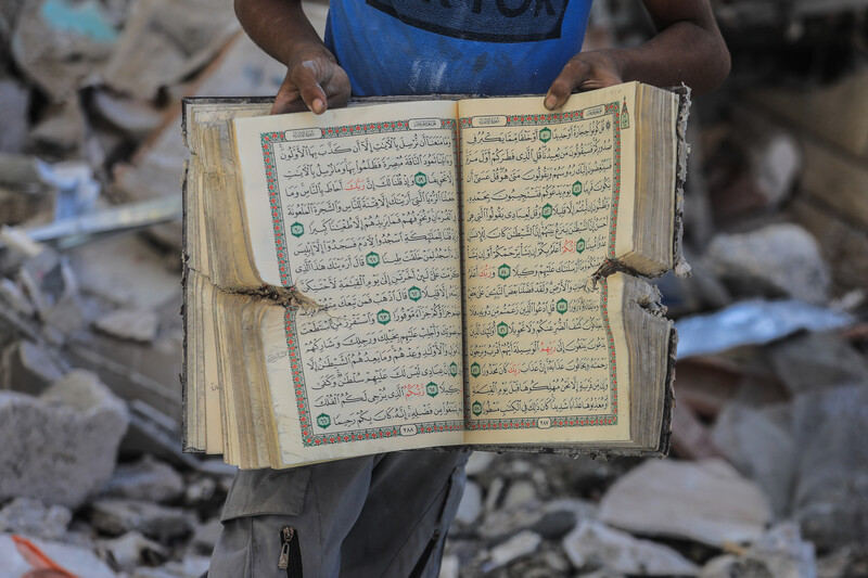 A man holds up a Quran