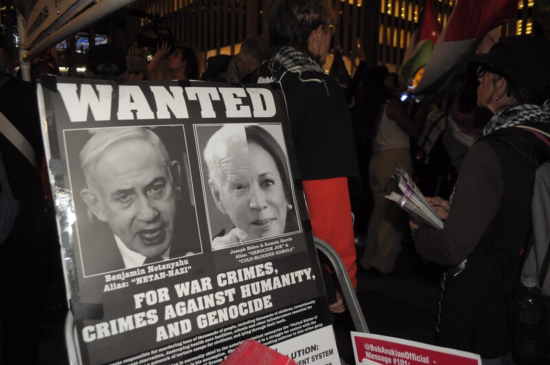 a poster decrying the war crimes of Netanyahu and Biden Harris