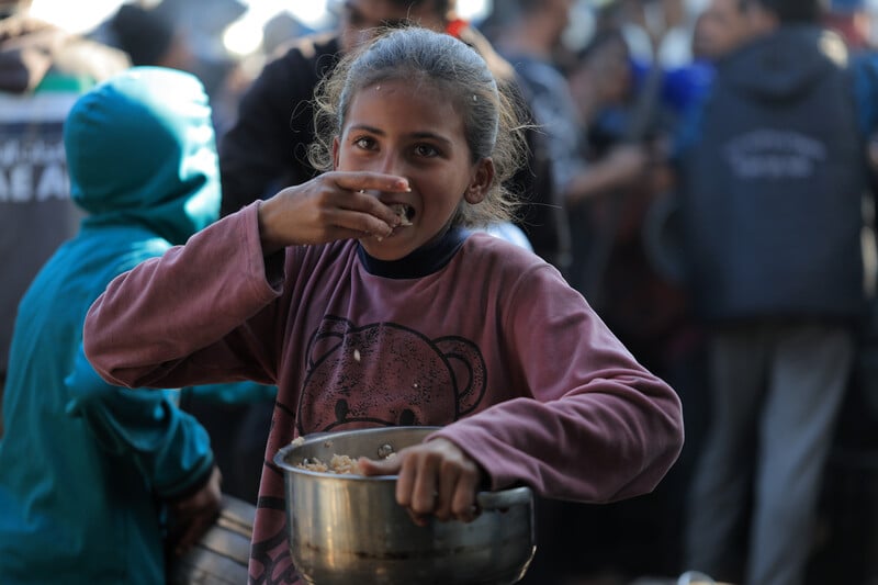 A child eats from a pot