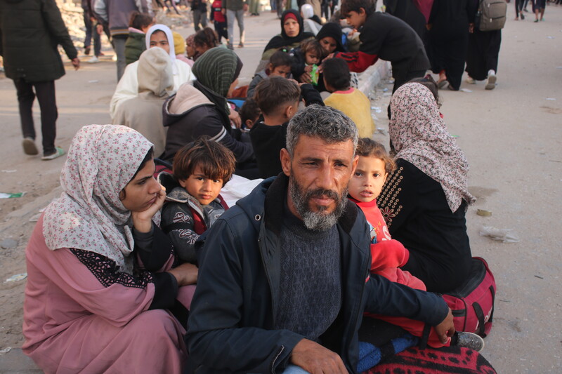 A man sits with his family