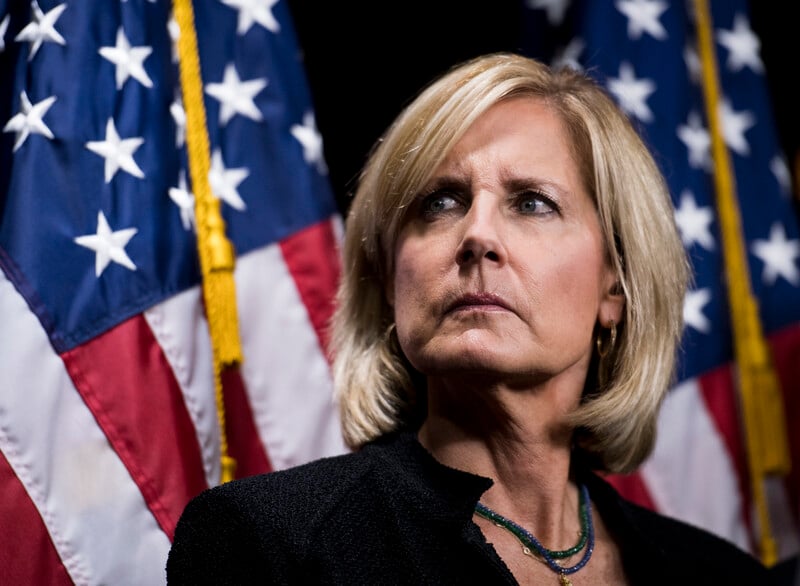 Congresswoman Claudia Tenney with two American flags behind her