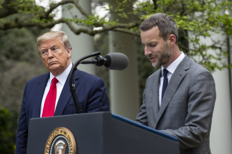 Donald Trump and Adam Boehler stand at a podium in the Rose Garden of the White House