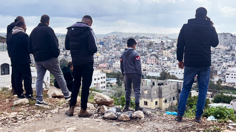 A group of people stand on a hilltop