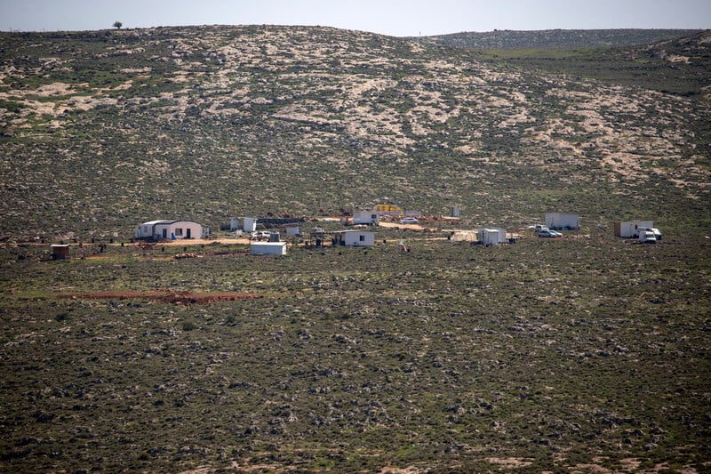 Landscape view of a collection of trailer and structures in a field 