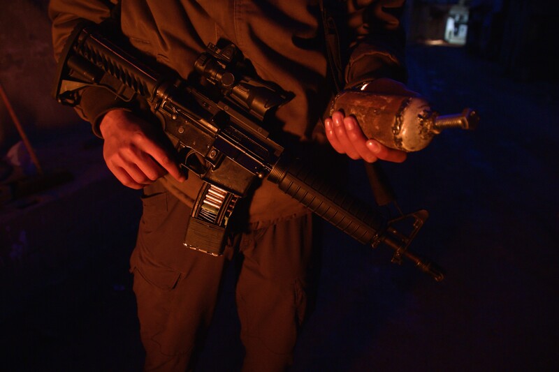 A Palestinian fighter in Jenin refugee camp carries a gun and an explosive device on 22 December 2024.