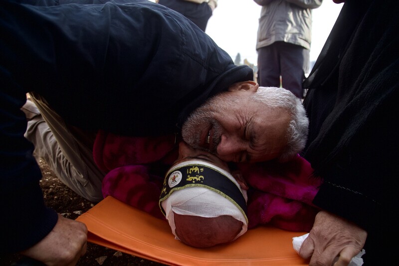 A grieving man rests his head on the body of a Palestinian killed during confrontations by Israeli forces during a funeral procession in Jenin, 3 February.