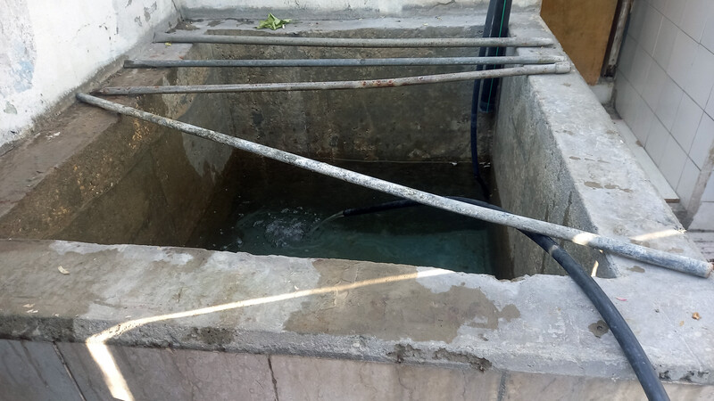 Pipes rest on top of a basin made of cinderblocks