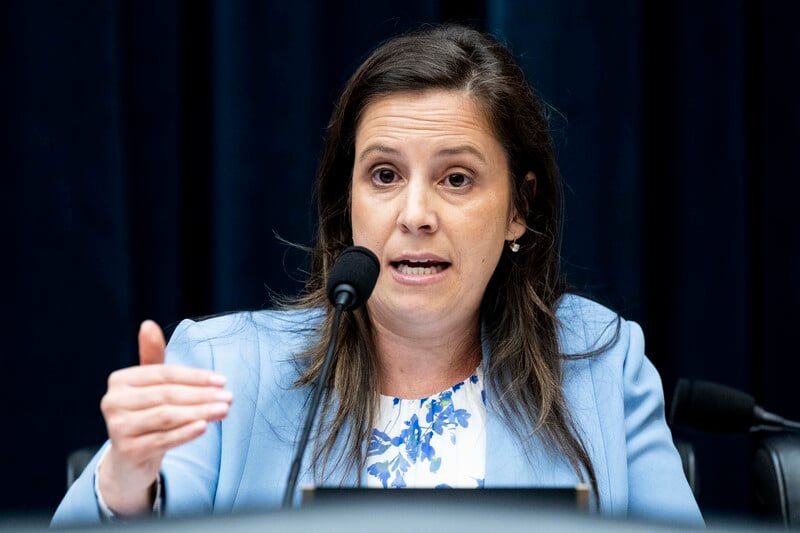 Congresswoman Elise Stefanik at microphone emphasizes a point with her hand