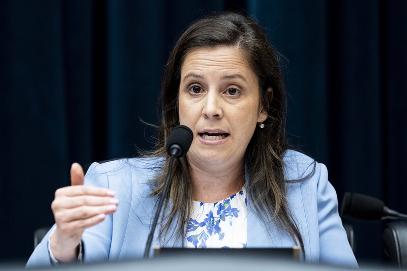 Congresswoman Elise Stefanik at microphone emphasizes a point with her hand