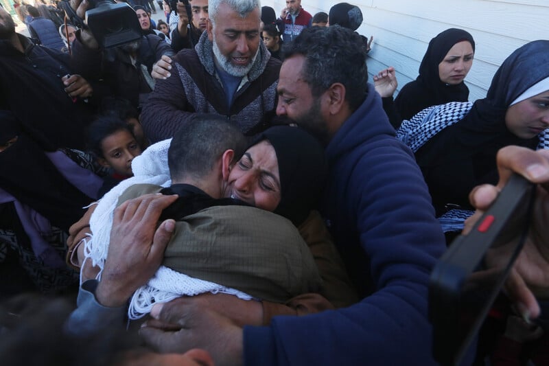 A woman hugs a man amid a crowd,