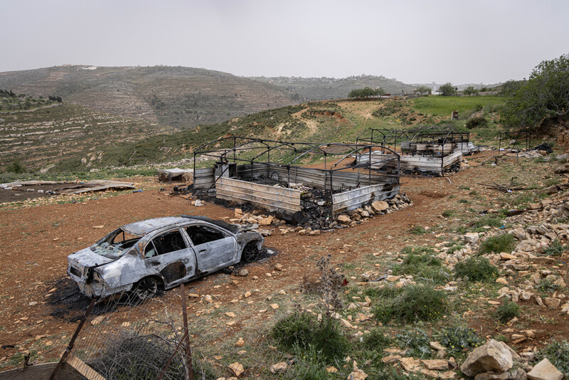 Landscape view of burned-out car and tent structures