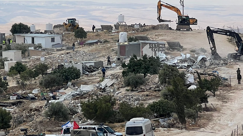 Bulldozers tear through a small village