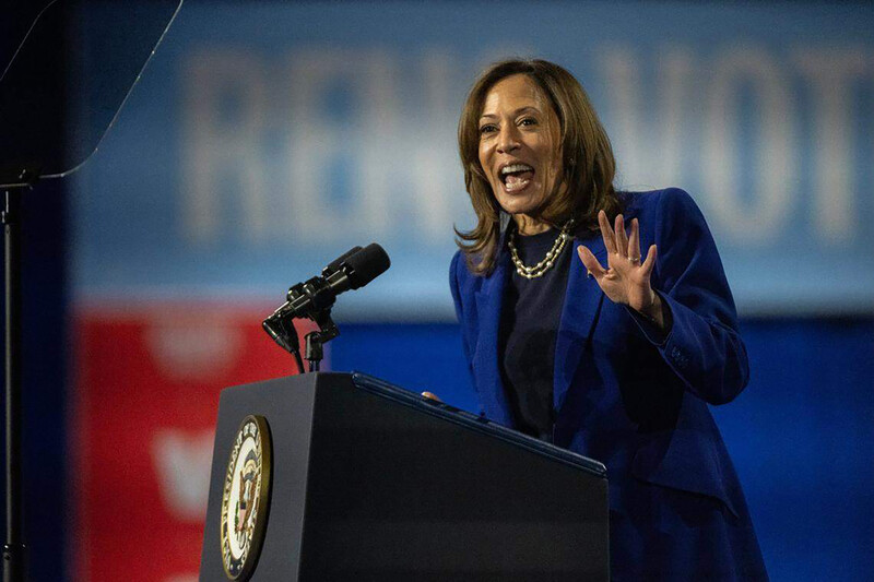 Kamala Harris gesticulates from behind a podium