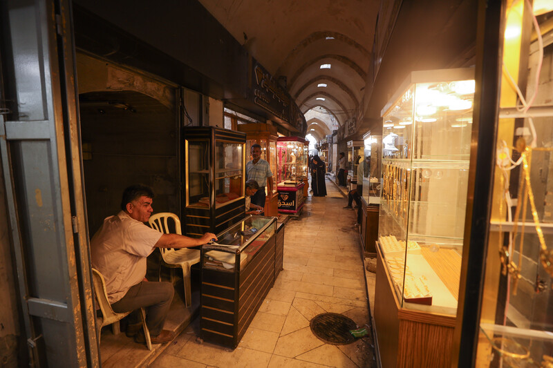 Shops in an alley displaying gold products.