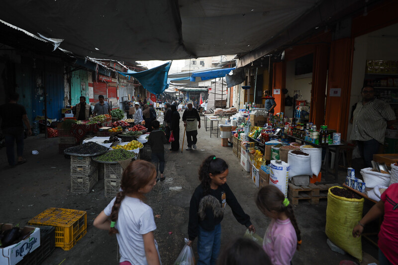 A number of vendors displaying their products in an alley.