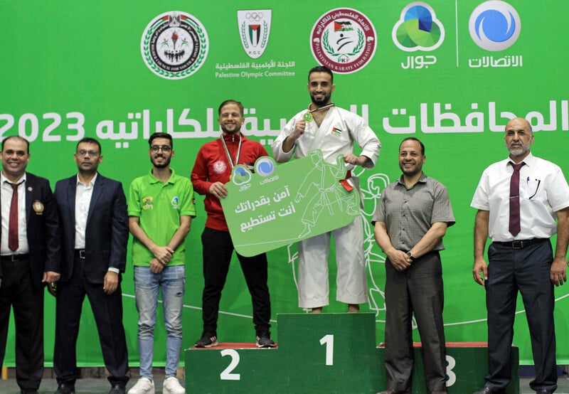 People pose with their medals on a podium