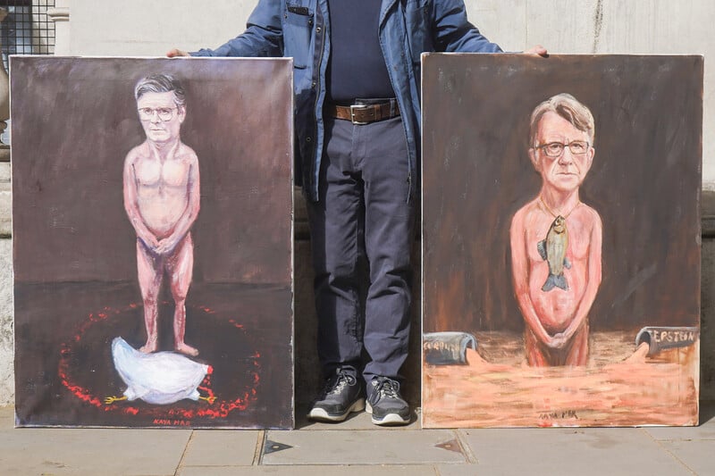 A man holds up two paintings