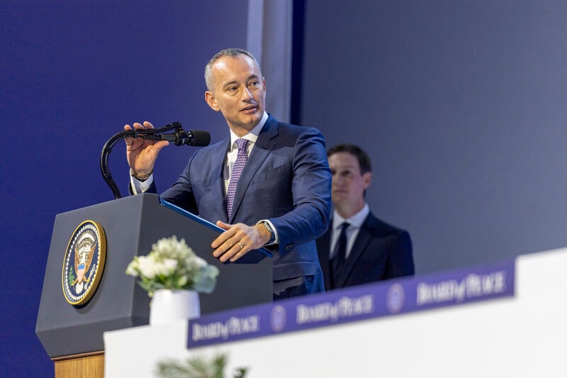 Man in suit speaks from a podium