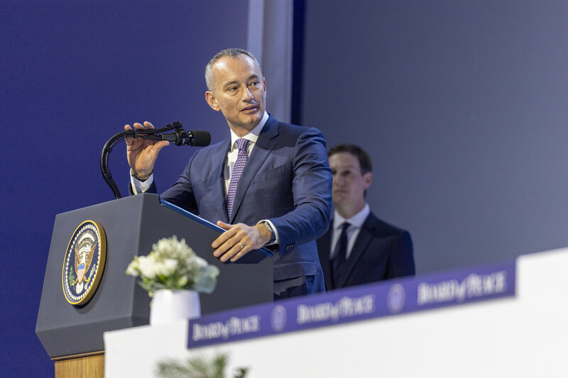 Man in suit speaks from a podium