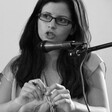 Portrait of seated Abir Kopty speaking into microphone