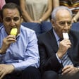 Two men, including Israeli president Shimon Peres, appear unhappy while eating ice cream