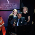 Man makes speech at podium while holding award