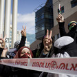 Women make victory sign with their hands during protest