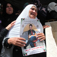 Mourning woman holds poster of slain child