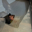 Boy peers through broken window