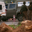 Mahmoud Shaalan's body lays on road behind Israeli military vehicles and group of soldiers