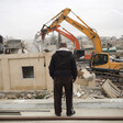 Man watches as heavy equipment is used to destroy home