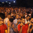 Hundreds of men pray outside at night
