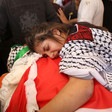 Sarah Shamasneh mourning over the body of her brother Muhammad Shamasneh during his funeral in Qatana